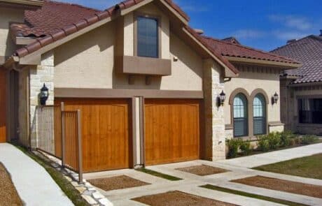 a condo exterior with wooden garage doors and stylized driveways at Escondera Condominiums in TX
